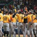 Jugadores de las Águilas Cibaeñas celebran después de conseguir la victoria que les mantiene la esperanza de lograr la clasificación para la Serie Final.