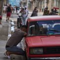 Un hombre habla con una persona dentro de un automóvil durante un apagón en La Habana, Cuba, el lunes 16 de marzo de 2026. (Foto AP/Ramón Espinosa)