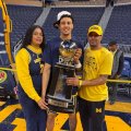 Yaxel Lenderborg junto a sus padres, Yisel Raposo y Okaris Lenderborg, con el trofeo de campeón en sus manos