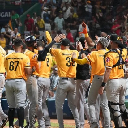 Jugadores de las Águilas Cibaeñas celebran después de conseguir la victoria que les mantiene la esperanza de lograr la clasificación para la Serie Final.