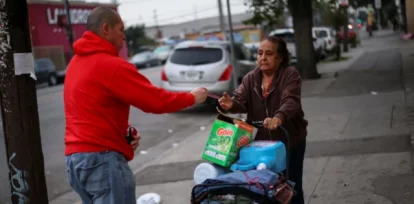 Ron Gochez, voluntario del grupo de defensa de los derechos de los inmigrantes Unión del Barrio, entrega una tarjeta roja de 