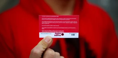 Ron Gochez, voluntario del grupo de defensa de los derechos de los inmigrantes Unión del Barrio, sostiene una tarjeta roja de 