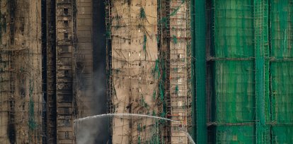 Bomberos trabajan para extinguir un incendio que comenzó el miércoles en Wang Fuk Court, un complejo residencial en el distrito de Tai Po en los Nuevos Territorios de Hong Kong, el jueves 27 de noviembre de 2025. (AP Foto/Chan Long Hei)