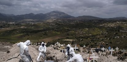 Trabajadores con trajes especiales sepultan el cuerpo de una víctima de covid-19 que nadie reclamó en el cementerio municipal de Tijuana, México (21 de abril) ,Trabajadores con trajes especiales sepultan el cuerpo de una víctima de covid-19 que nadie reclamó en el cementerio municipal de Tijuana, México (21 de abril)