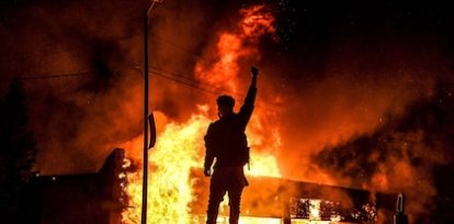 Un manifestante durante las protestas en el centro de Minneapolis por la muerte de George Floyd, que terminaron en rotura de vidrieras y quemas de negocios (29 de mayo),Un manifestante durante las protestas en el centro de Minneapolis por la muerte de George Floyd, que terminaron en rotura de vidrieras y quemas de negocios (29 de mayo)