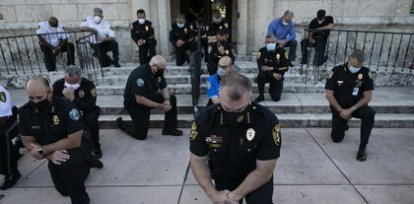 Policías se arrodillan en un gesto de apoyo a la manifestación contra la violencia policial en Coral Gables, Florida (30 de mayo) ,Policías se arrodillan en un gesto de apoyo a la manifestación contra la violencia policial en Coral Gables, Florida (30 de mayo)