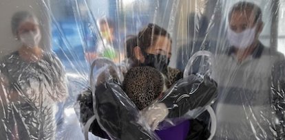 Elisabete Nagata abraza a su cuñada de 76 años a través de una cortina de plástico en un hogar para ancianos en San Pablo, Brasil (13 de junio) ,Elisabete Nagata abraza a su cuñada de 76 años a través de una cortina de plástico en un hogar para ancianos en San Pablo, Brasil (13 de junio)
