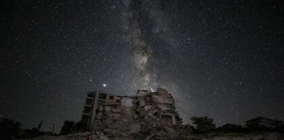 Un hombre fuma en la noche fente a un edificio destruido por los bombardeos sobre la ciudad rebelde siria de Ariha (27 de junio),Un hombre fuma en la noche fente a un edificio destruido por los bombardeos sobre la ciudad rebelde siria de Ariha (27 de junio)