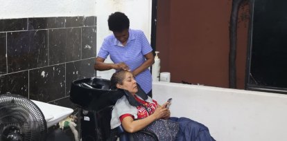 Le lavan el pelo a señora en el salón de belleza