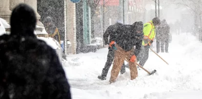 Personas retiran nieve de una acera, el 25 de enero de 2026, en Toronto (Canadá). EFE