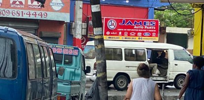 Una señora intenta cruzar las calles anegadas
