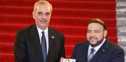 Miguel Reyes Sánchez entrega  al presidente Abinader el libro.