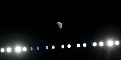 Un eclipse lunar parcial, visto por encima de las luces del estadio durante un partido de pretenporada de la NFL entre los Browns de Cleveland y los Patriots de Nueva Inglaterra, el 27 de agosto de 2026, en Cleveland. (AP Foto/Carolyn Kaster)