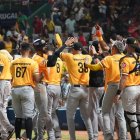 Jugadores de las Águilas Cibaeñas celebran después de conseguir la victoria que les mantiene la esperanza de lograr la clasificación para la Serie Final.