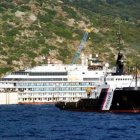 A view of the luxury cruise ship Costa Concordia during the operations to put it afloat, on the tiny Tuscan island of Giglio, Italy, Monday, July 14, 2014.  The shipwrecked Costa Concordia has been successfully put afloat in preparation to tow it away for scrapping. Authorities expressed satisfaction that the operation to float the Concordia from an underwater platform had proceeded without a hitch early Monday. The cruise liner struck a reef in January 2012 and capsized, killing 32 people. (AP Photo/Alessandro La Rocca, LaPresse) ITALY OUT