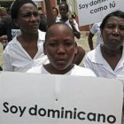 En esta foto del 12 de agosto de 2013, un joven descendiente de haitianos exhibe una pancarta en que se proclama dominicano durante una protesta para demandar al presidente Danilo Medina que detenga el proceso destinado a invalidar sus certificados de nacimientos que los reconoce con la nacionalidad dominicana. Miles de personas que tienen la nacionalidad dominicana la perderían luego de que el tribunal constitucional de República Dominicana ordenó el jueves 26 de septiembre de 2013 dar tratamiento de extranjeros a todos los nacidos en el país desde 1929 pero de padres inmigrantes ilegales, especialmente haitianos. (AP Photo/Ezequiel Abiu Lopez, File)