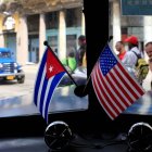 Fotografía de archivo del 22 de marzo de 2013 de dos pequeñas banderas de Cuba y Estados Unidos sobre el tablero de instrumentos de un automóvil en La Habana, Cuba. 