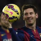 Barcelona’s Argentinian forward Lionel Messi leaves the pitch with the ball after his hat-trick after the Spanish league football match FC Barcelona vs RCD Espanyol at the Camp Nou stadium in Barcelona on December 7, 2014. Barcelona won the match 5-1.  AFP PHOTO/ LLUIS GENE. Foto de Archivo