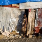 In this Oct. 31, 2016 photo, Nathanaelle Bernard, who is 7 months pregnant, steps outside from a makeshift hut where she now lives, after her home was destroyed by Hurricane Matthew, in Coteaux, Haiti. The 19-year-old is among the nearly 14,000 women who are due to give birth in the coming weeks amid widespread shortages of food, water and housing. (AP Photo/Dieu Nalio Chery)