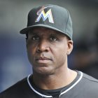 FILE - This July 6, 2016, file photo shows Miami Marlins hitting coach Barry Bonds in the dugout before a baseball game against the New York Mets at Citi Field in New York. The Miami Marlins have fired hitting coach Barry Bonds, third base coach Lenny Harris and bullpen coach Reid Cornelius. The Marlins announced the changes on Wednesday, Oct. 5, 2016. (AP Photo/Seth Wenig, File)