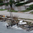 Un bote y escombros aparecen arrimados entre la playa y la pista en Melbourne, Florida, el viernes 7 de octubre del 2016. El huracán Matthew se debilitó a tormenta categoría 1 el sábado 8 de octubre del 2016 pero sigue siendo una amenaza para las costas de Georgia y las Carolinas. El Centro Nacional de Huracanes en Miami dijo el sábado por la mañana que Matthew estaba centrado a unos 30 kilómetros (20 millas) al sur-sureste de Charleston, South Carolina. (AP Foto/Gaston De Cárdenas)