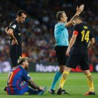 Barcelona's Argentinian forward Lionel Messi sits on the ground (L) before leaving the pitch during the Spanish league football match FC Barcelona vs Atletico de Madrid at the Camp Nou stadium in Barcelona on September 21, 2016. / AFP / PAU BARRENA