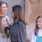 Se observa cómo la esposa de Felipe VI se acerca a sus hijas y a su suegra para decirles algo y toca el pelo a Leonor, Princesa de Asturias y heredera de la Corona española, que en ese momento aparta de su hombro la mano de su abuela. . REUTERS/Enrique Calvo