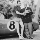 Porfirio Rubirosa junto a un auto de carrera.