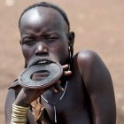 ETIOPIA- ELECCIONES:ETH01 PARQUE NACIONAL DE MAGO (ETIOPIA) 14/05/05 : Una mujer de la tribu Mursi, conocidos como la 'gente de la mañana', escucha a los ancianos durante una reunión sobre las elecciones de mañana en el Parque Nacional de Mago, a 550 kilómetros de Addis Abeba, hoy sábado 14 de mayo. Los Mursi, de los que sólo quedan unas 5.000 personas viviendo según las antiguas tradiciones, se adornan de forma elaborada, con turbantes, adornos tallados en los labios y cicatrices en forma de luna en los brazos de muchos de los hombres, cada una de ellas una insignia de honor que demuestra que han matado a un miembro de otra tribu. Los etíopes votan mañana domingo en unas elecciones que se consideran como una prueba de la voluntad del partido gubernamental por instaurar la democracia en el país. EFE/Stephen Morrison