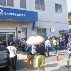 Decenas de personas hacen fila en una sucursal bancaria antes del cierre a las 12:30 p. m. Duany Nuñez.