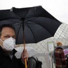 Un turista con una mascarilla en las inmediaciones del Museo del Louvre, en París, el 2 de marzo de 2020. (AP Foto/Christophe Ena)