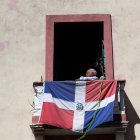 - Un anciano observa desde su balcón, donde tiene colgada una bandera dominicana, este domingo . Van tres fallecidos por coronavirus EFE/Orlando Barría