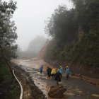 Trabajadores caminan por una carretera bloqueada por un deslizamiento de tierra a raíz del huracán Eta en San Cristóbal Verapaz, Guatemala, el sábado 7 de noviembre de 2020. Socorristas buscaban al menos a 100 personas desaparecidas por el deslave. (Foto AP / Moisés Castillo)
