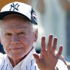 FILE - In this June 12, 2016 file photo, former New York Yankees pitcher Whitey Ford waves to fans from outside the dugout at the Yankees' annual Old Timers Day baseball game in New York. A family member tells The Associated Press on Friday, Oct. 9, 2020 that Ford died at his Long Island home Thursday night.  (AP Photo/Kathy Willens, File)