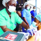 Hospital staff receives one of the country's first coronavirus vaccinations, using the AstraZeneca vaccine manufactured by the Serum Institute of India and provided through the global COVAX initiative, at Yaba Mainland hospital in Lagos, Nigeria Friday, March 12, 2021. Urgent calls for COVID-19 vaccine fairness rang through African countries on Friday as more welcomed or rolled out doses from the global COVAX initiative, with officials acutely aware their continent needs much more. (AP Photo/Sunday Alamba)