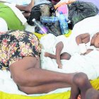 Injured children and their parents sleep on mattresses, on the floor of the Immaculee Conception hospital, in Les Cayes, Haiti, Monday, Aug. 23, 2021, a week after a 7.2 magnitude earthquake hit the area. (AP Photo/Matias Delacroix)