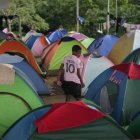 ARCHIVO - Un migrante que cruzó a pie el Tapón del Darién desde Colombia, camina entre tiendas de campaña en un campamento temporal en Lajas Blancas, Panamá, el 28 de junio de 2024. El número de niños y adolescentes que cruzan sin acompañantes la frontera entre Panamá y Colombia a través de la peligrosa selva de Darién creció en un 35% hasta noviembre de 2024, de acuerdo con la información divulgada por Unicef el miércoles 18 de diciembre de 2024. (Foto AP/Matias Delacroix, Archivo