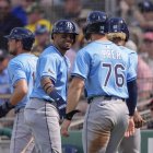 Kenny Piper es recibido después de anotar con un triple productor de 3 carreras de Junior Caminero, de Rays.
