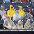 Aficionados desafían la lluvia durante en el partido entre  Rays  y los Cerveceros.