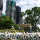 Personas ofrecen flores a las víctimas del incendio en la urbanización residencial del distrito de Tai Po, en Hong Kong, el lunes 1 de diciembre de 2025.