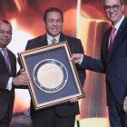 El poeta José Mármol y el economista Euri Cabral entregan a José Rafael Lantigua un reconocimiento.