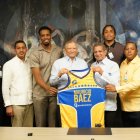 El presidente del Banco de Reservas, Leonardo Aguilera, recibe una camiseta de Leo Corporán, asesor de MB: a la derecha figura con Gerardo, el JMV y la Copa de campeón.