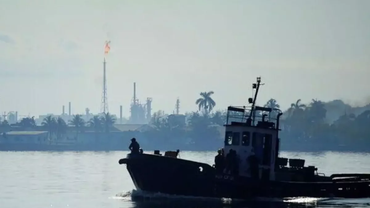 Un bote pasa frente a la refinería Ñico López en la bahía de La Habana