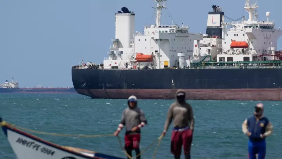 Pescadores pasan junto a un buque petrolero en el golfo de Venezuela frente a la costa de Punta Cardón, Venezuela