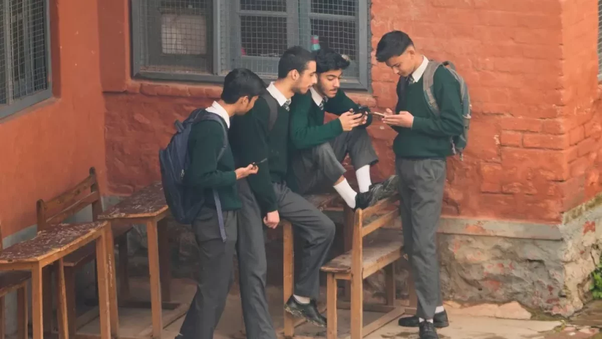Varios estudiantes revisan sus teléfonos celulares en un complejo escolar de Srinagar, en la parte de Cachemira controlada por India