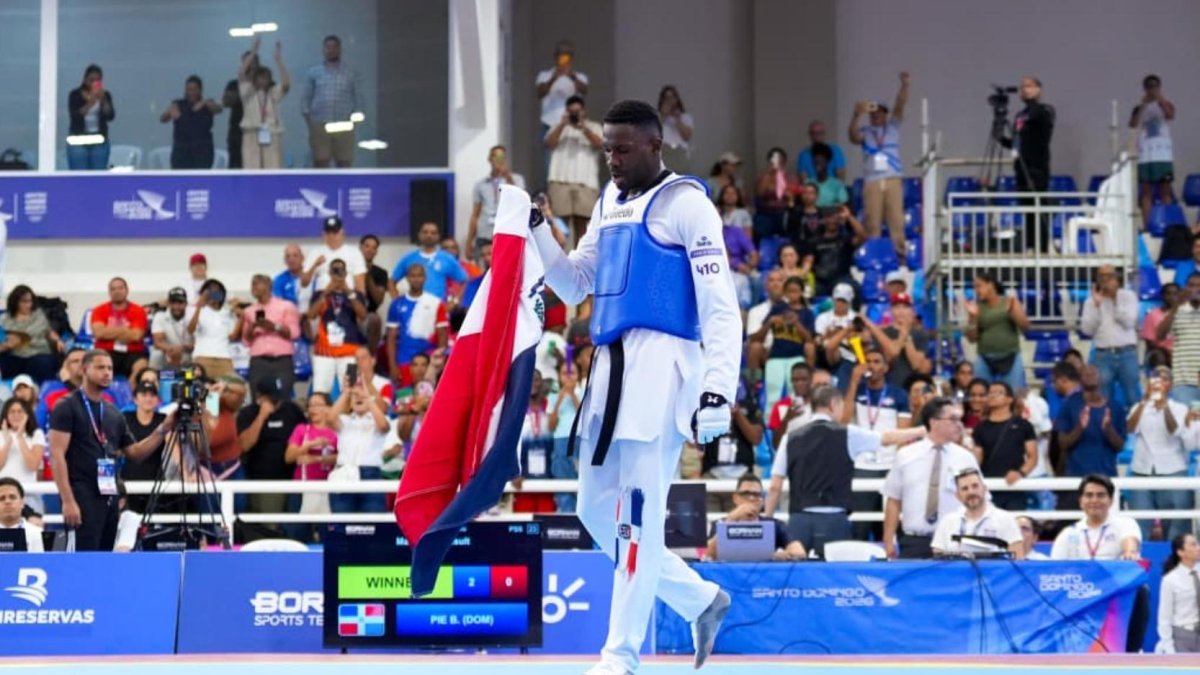 Bernardo Pie, portando la bandera dominicana, celebra su tercera medalla de oro en Juegos Centroamericanos.