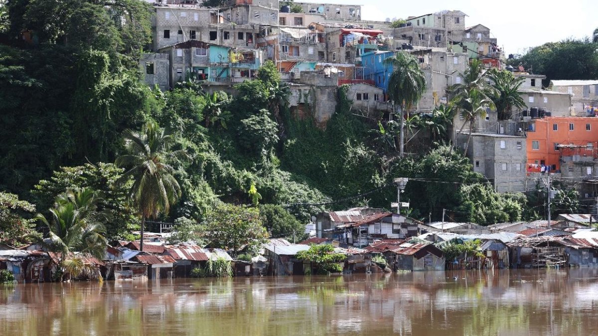Precarias viviendas parecen flotar en el agua en el río Ozama