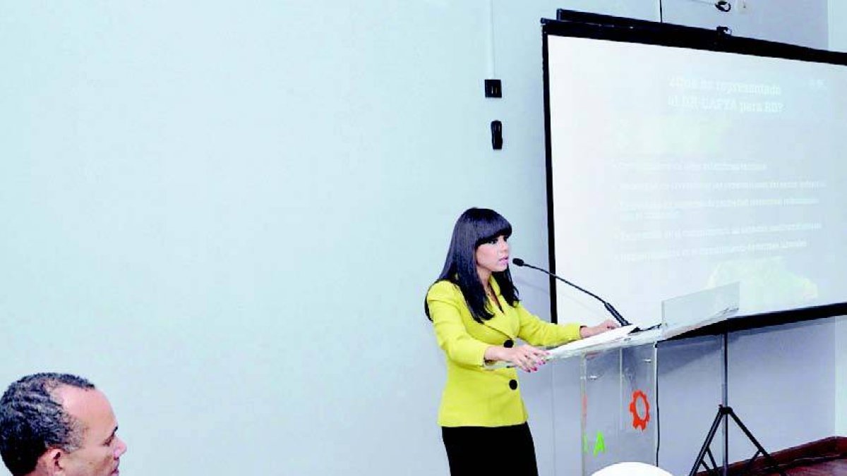 La directora general de Comercio Exterior, Katrina Naut, expone sobre DR-Cafta en tertulia de la Asociación de Empresas Industriales de Herrera (AEIH).  Observa el presidente de la AEIH, Víctor Castro