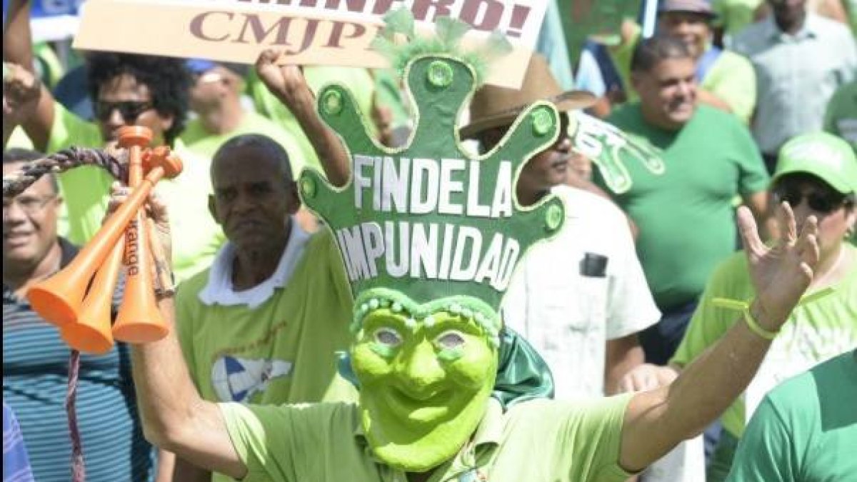 Una persona luce una careta verde en la que se lee Fin de la Impunidad/Foto tomada de las redes.