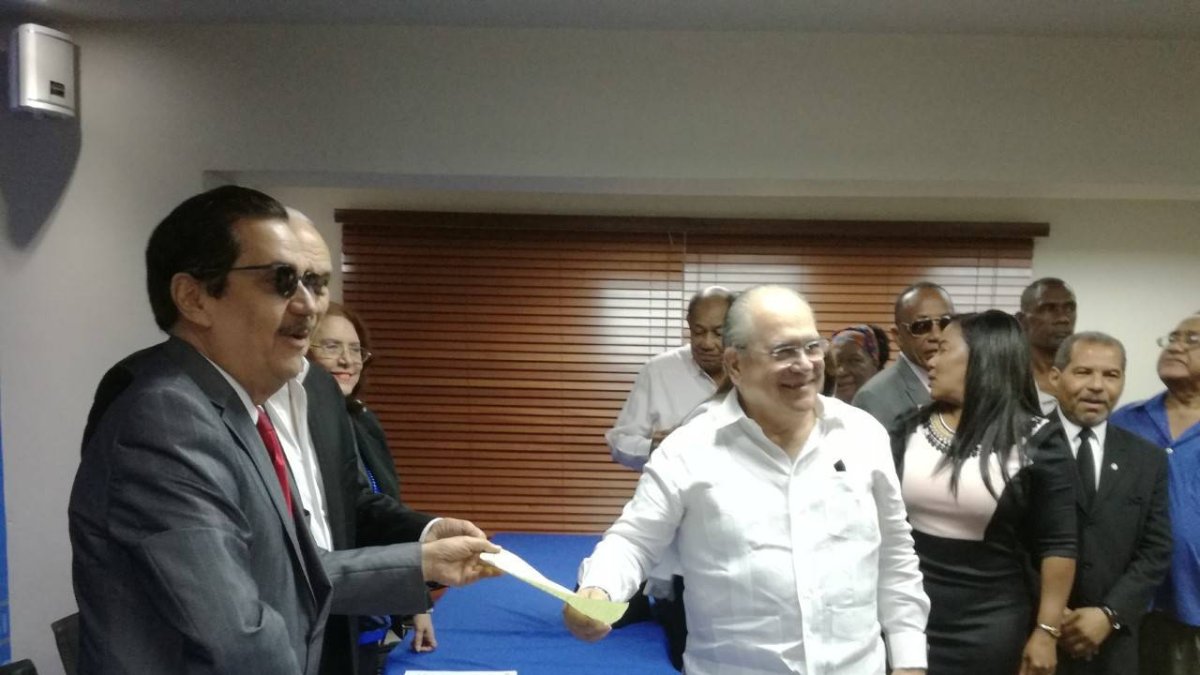 Jesus Feris entregando documentos a Tony Raful